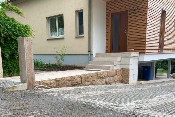 Eingang zu einem modernen Haus mit Holzverkleidung und gestuftem Zugang.