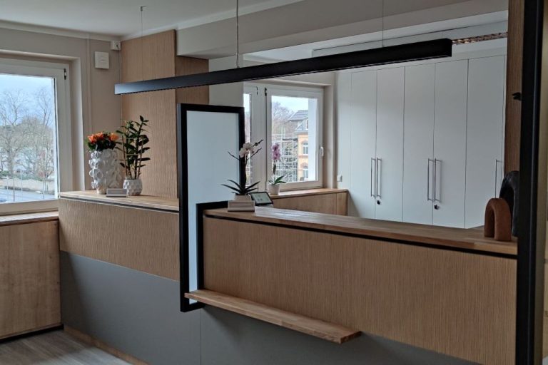 Moderne Küchenzeile mit Holzverkleidung und großzügigen Fenstern, Pflanzen und minimalistischer Beleuchtung.