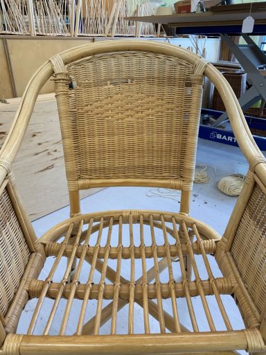 Ein unvollendeter, geflochtener Stuhlrahmen aus Rattan.