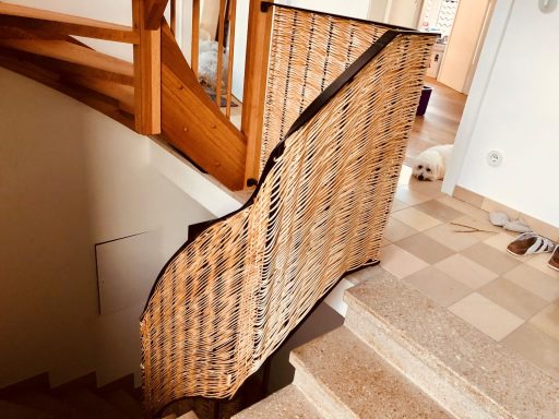 Holzgeländer einer Treppe mit einer geschwungenen Form und schmalen Streben.