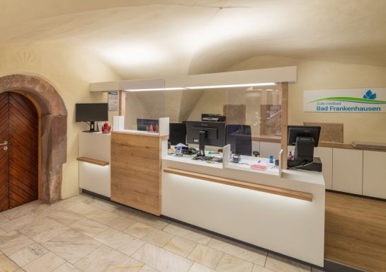 Moderne Rezeptionsdesk in einem hellen, freundlichen Empfangsbereich.