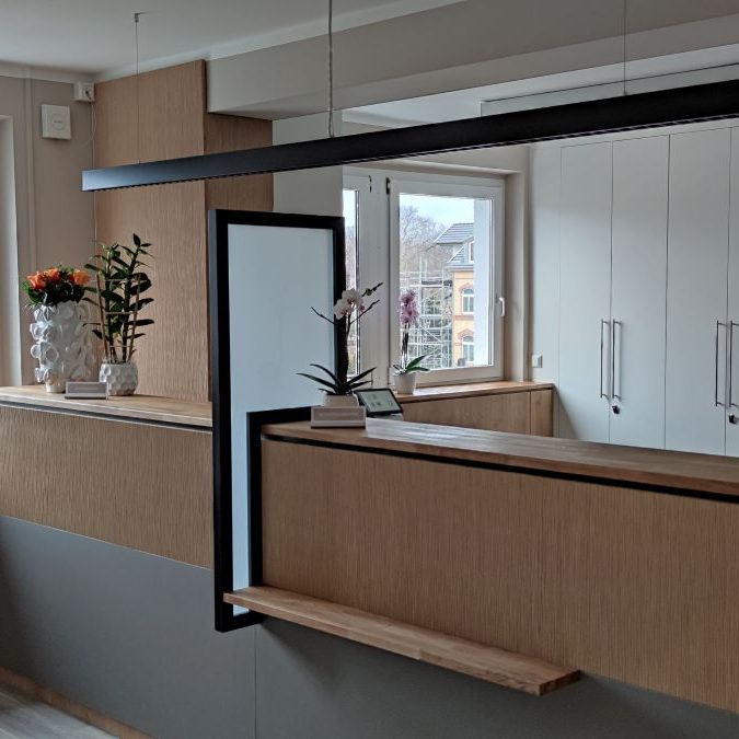 Moderne Innenraumgestaltung mit Holzregalen, Pflanzen und Fensterlicht.