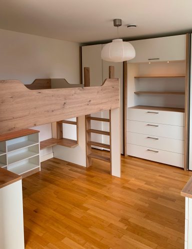 Helle Kinderzimmer mit Hochbett, Schrank und Holzfußboden.